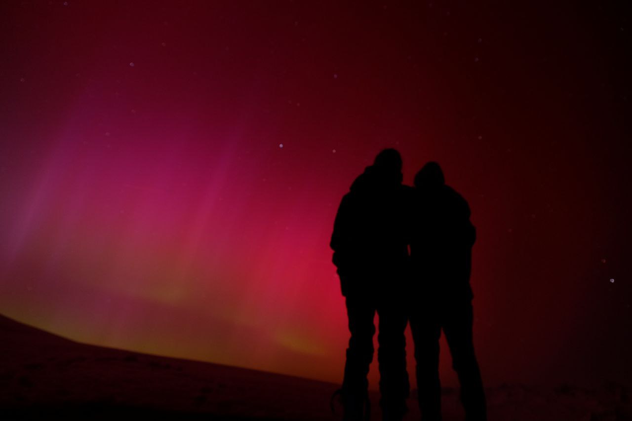 Polarlights in the Swiss Alps in May 2024. Miriam and me watching the red-pink lights. Photo taken by Sirah.